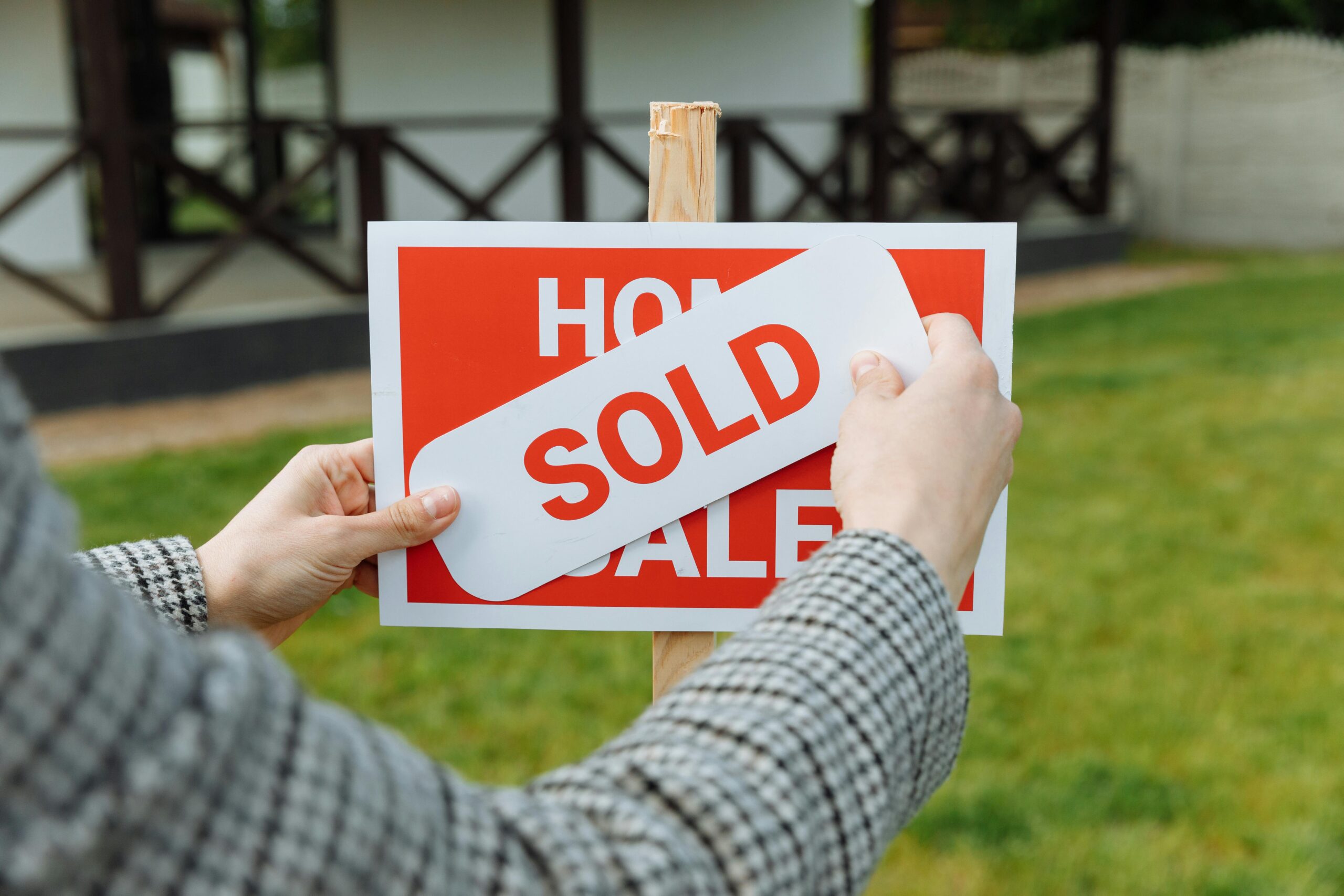 house for sale sign being covered with a sold sticker